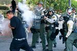 A law enforcement officer uses tear gas on a protester in Los Angeles, June 11, 2025