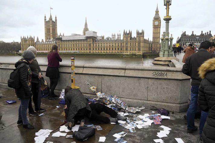 An injured woman is assisted after the terrorist attack on Westminster Bridge