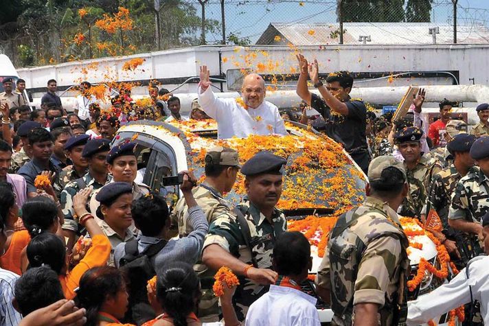 Amit Shah greets supporters at the Agartala airport in Tripura