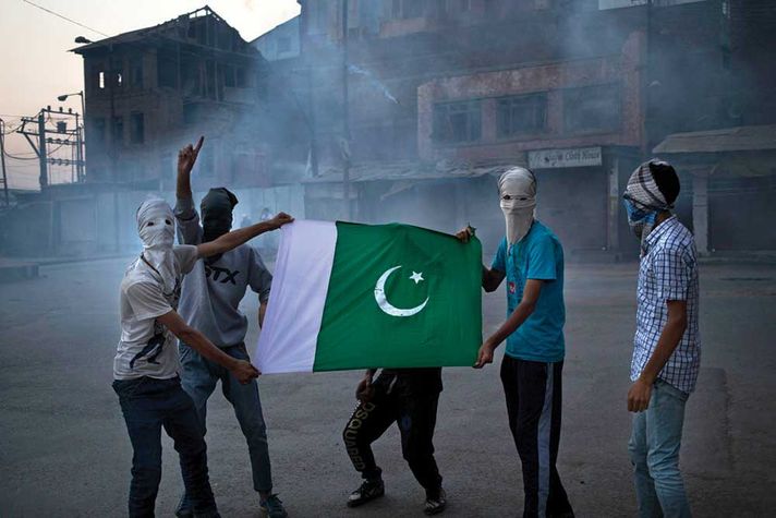 Kashmiri protestors hold a Pakistani flag in Srinagar