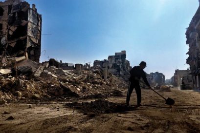 A Syrian worker clears debris