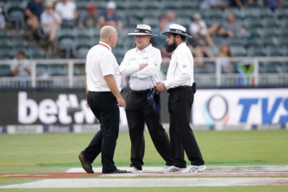 Umpires Ian Gould (C) Aleem Dar (R) and referee Andy Pycroft discuss ahead of suspending the match during the third day of the third test match