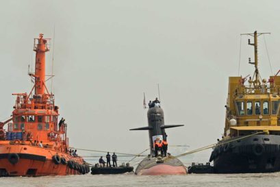 Tug boats escort the Scorpene submarine 'Kalvari' as it cruises into the Naval Dockyard in Mumbai on October 29, 2015