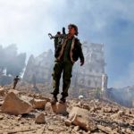 A Houthi fighter amidst the rubble of an air strike in Sana’a, Yemen