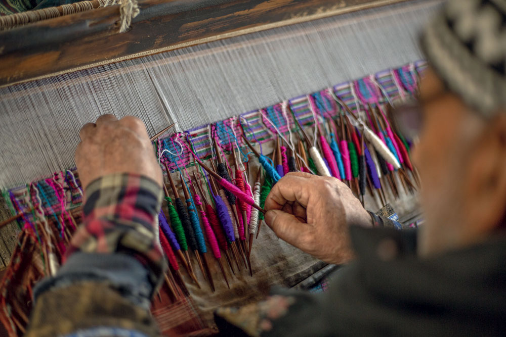 An artisan weaves a kani shawl, which holds a GI tag, on pashmina yarn, Kanihama village