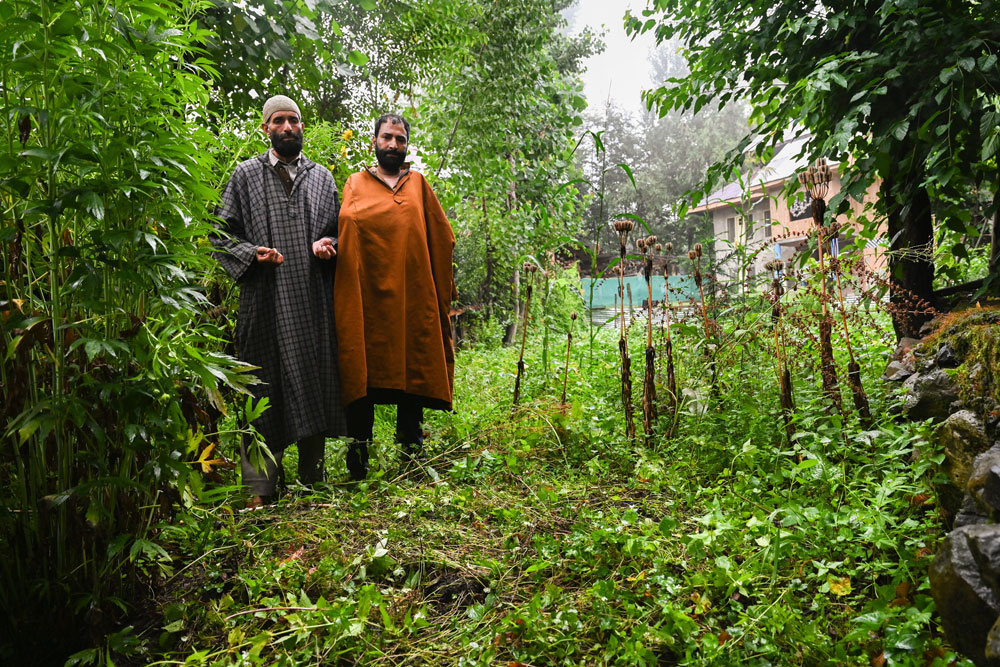 Mohammad Ashraf Bhat (Left) And Muzaffar Ahmad Bhat: The brothers offer prayers near the corner of their courtyard in Hapatnar where their father and brother lie buried without tombstones—victims of a terrorist execution in January 2003. Branded mukhbirs (informers), they were abducted, beheaded, and denied the dignity of a community funeral. 